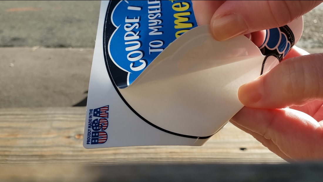 Image of a hand bending the backing of a kiss-cut sticker to make it easier to peel.